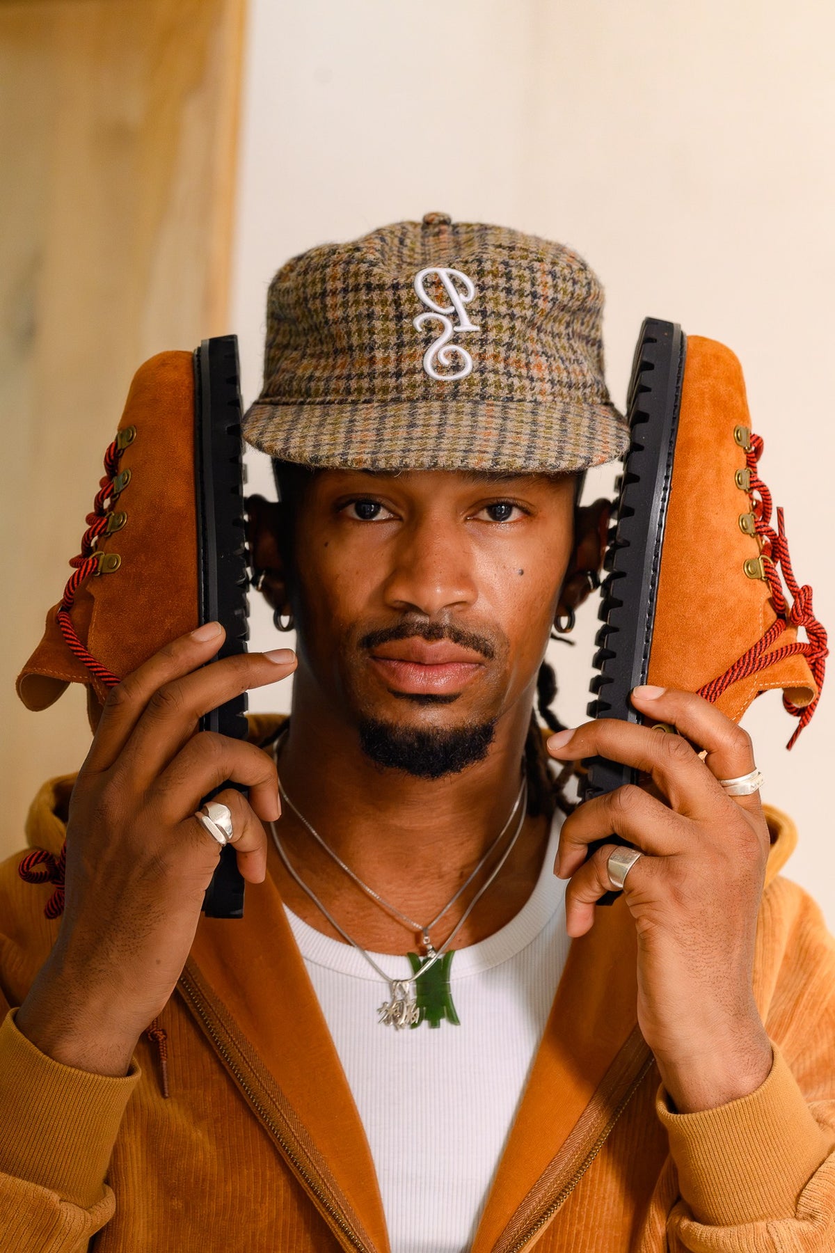 Paper Straight houndstooth cap, worn while holding a pair of rust Summit Mules