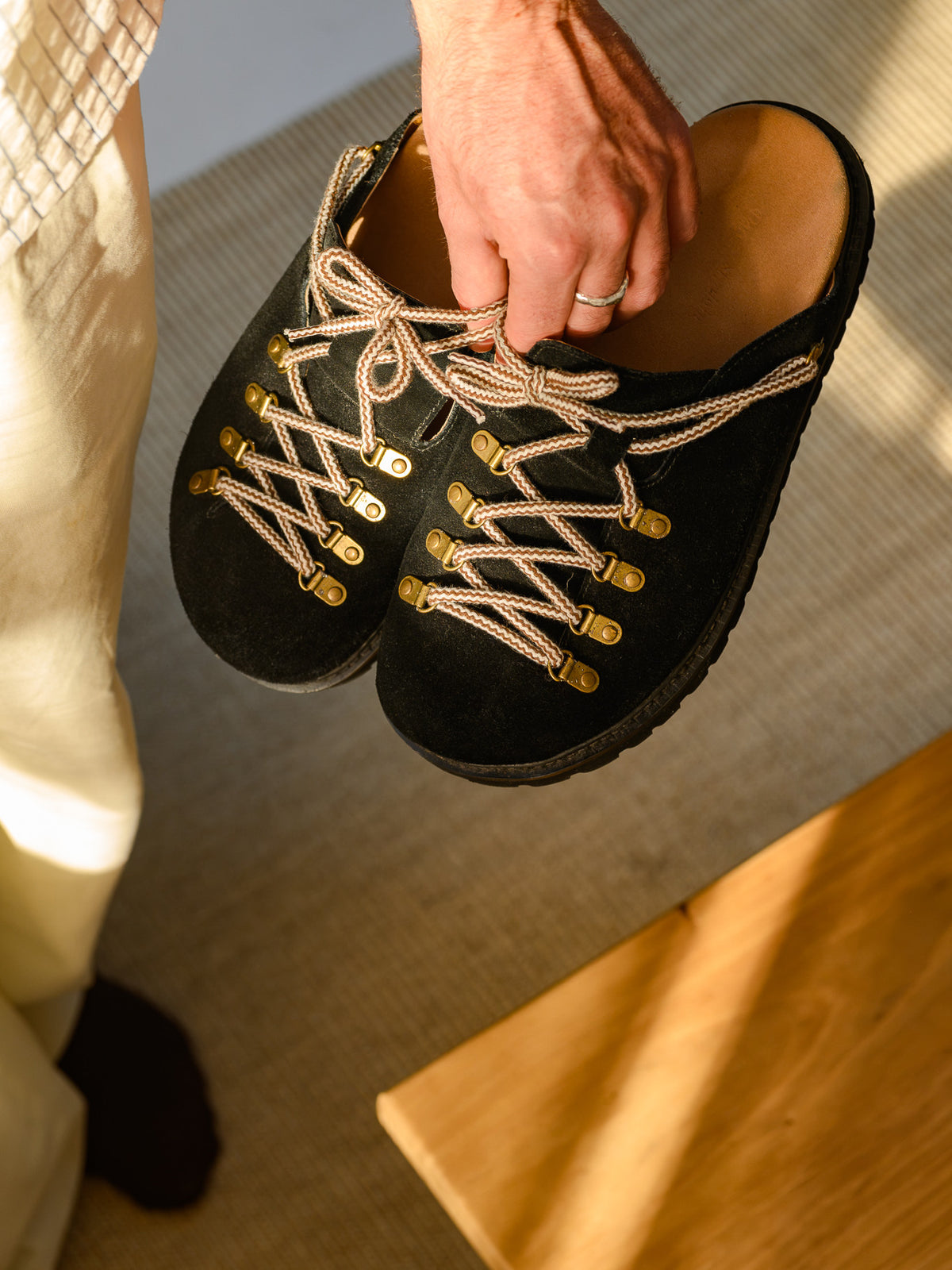 Paper Straight Summit Mule Black — pair held in one hand, angled view