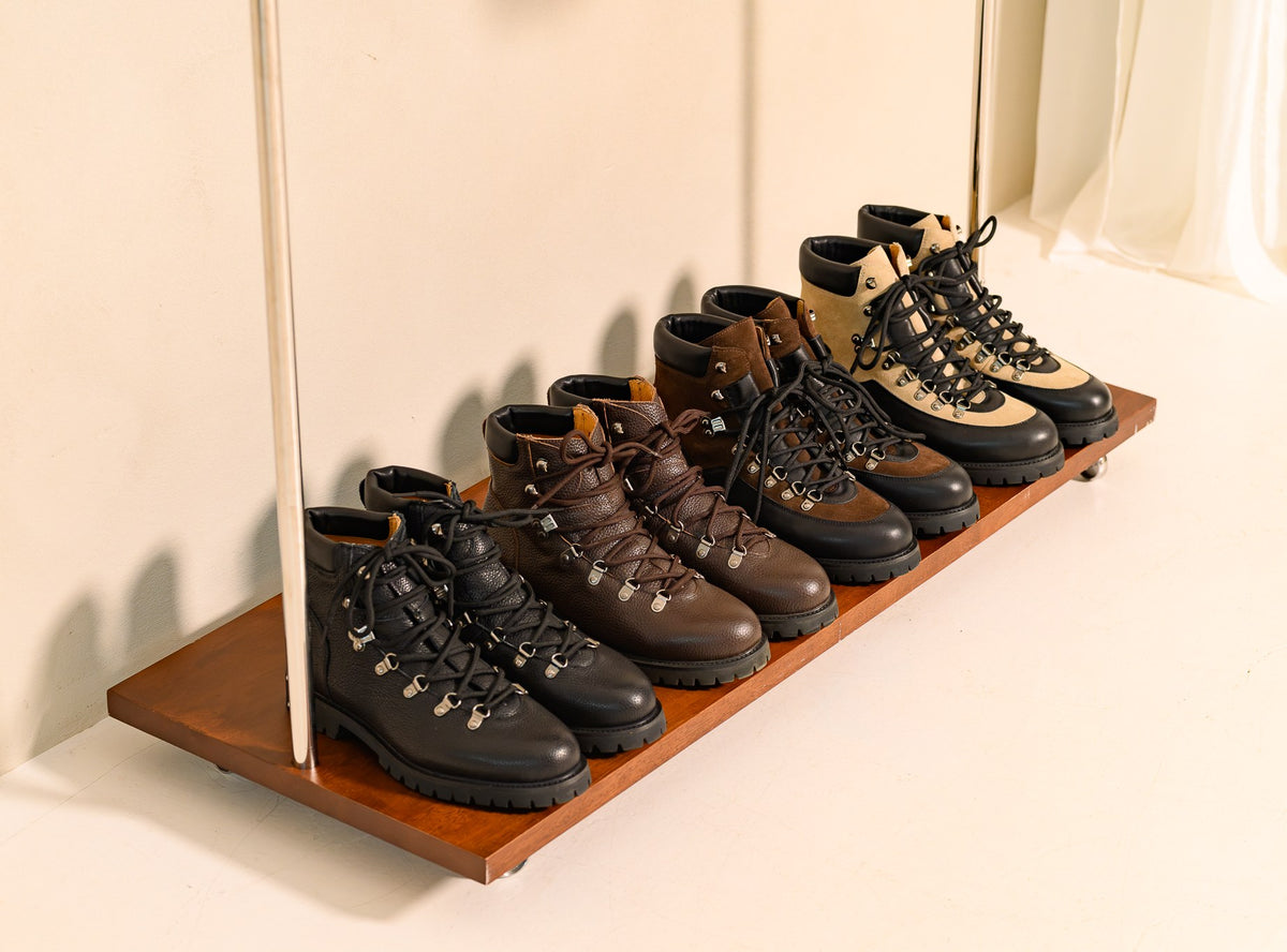 Four pairs of Paper Straight Ridgeworks High boots lined up on a wooden tray
