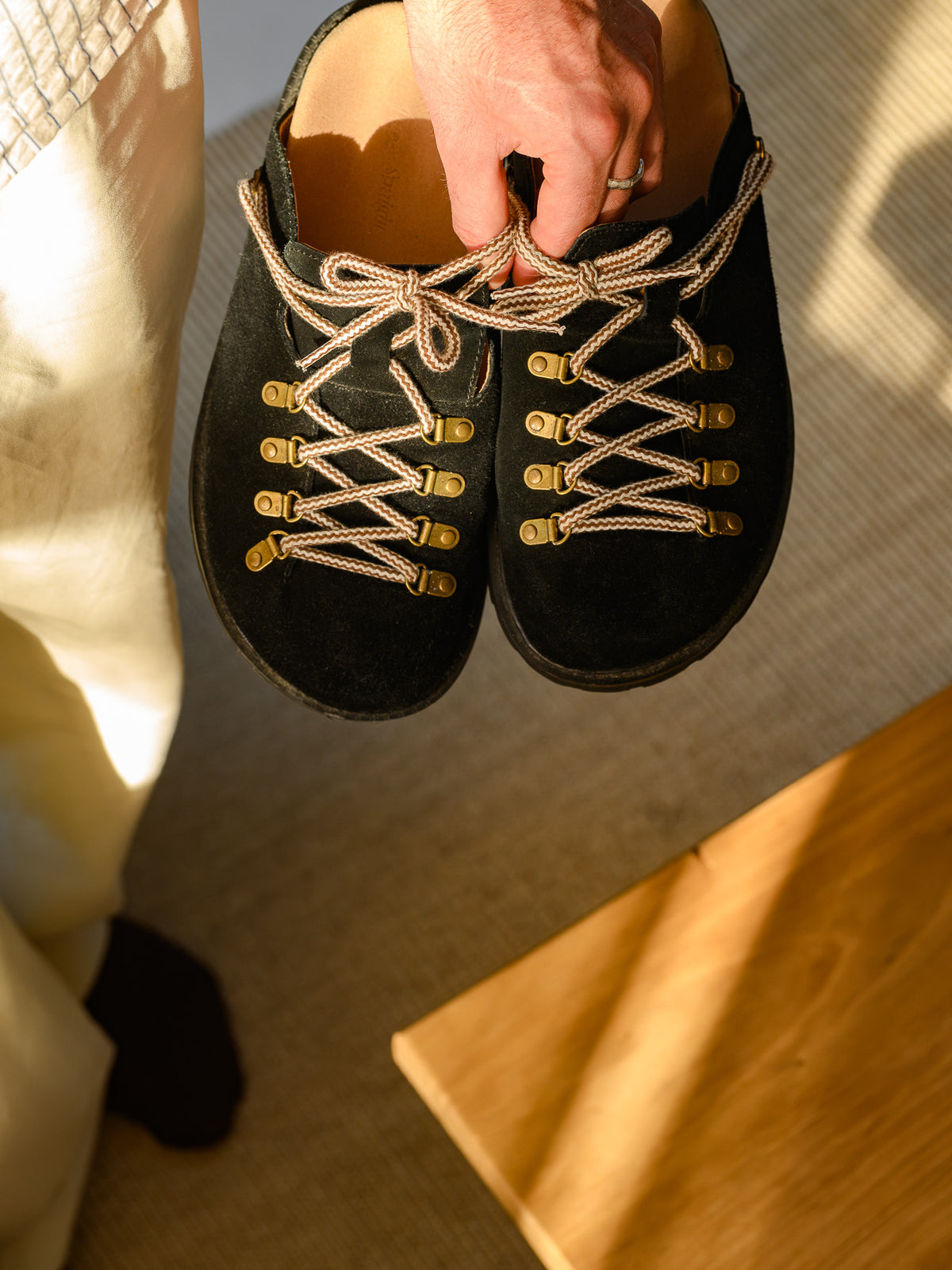 Paper Straight Summit Mule Black — pair held in one hand, seen from above